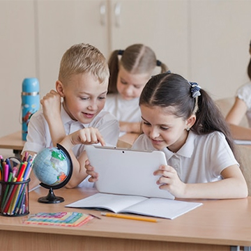 children looking at tablet in class