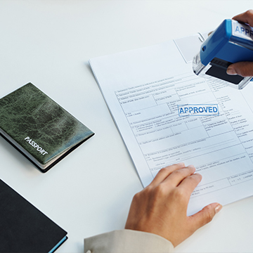 person marking papers with a stamp
