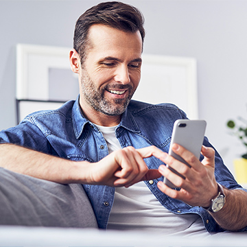 the man smiling while looking at phone