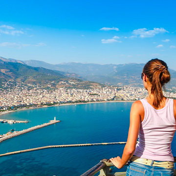 woman looking at city from a balcony